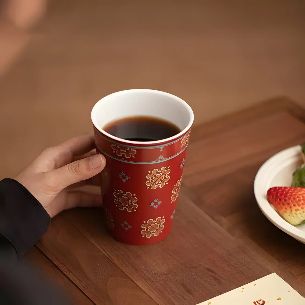 Red glaze floral medallion ceramic cup filled with tea